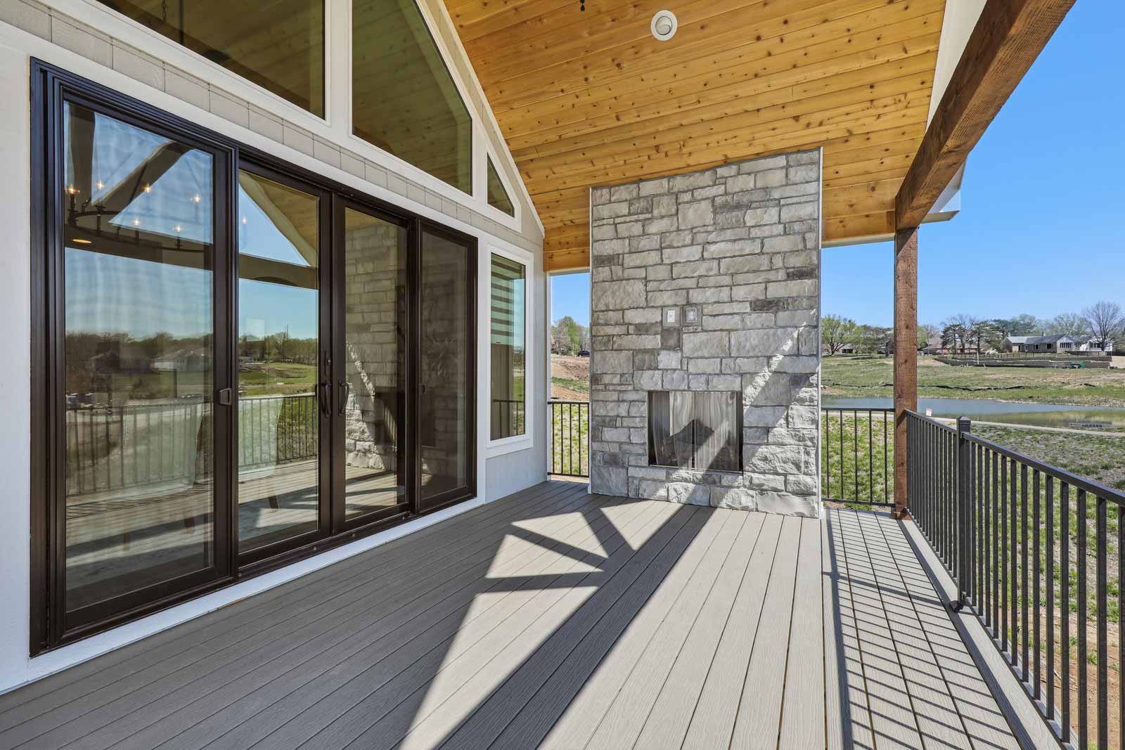 Covered deck with fireplace and double door entry to Kenneth Estates home