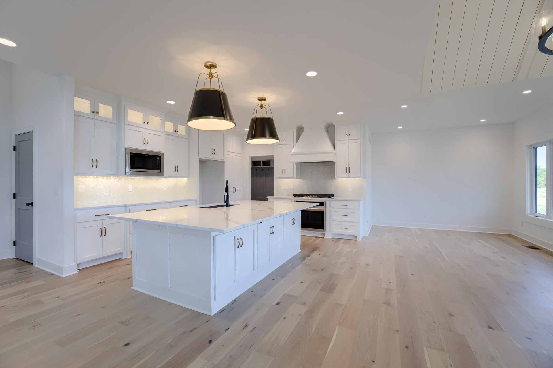 Kitchen and dining space with light wood floors in Kenneth Estates home